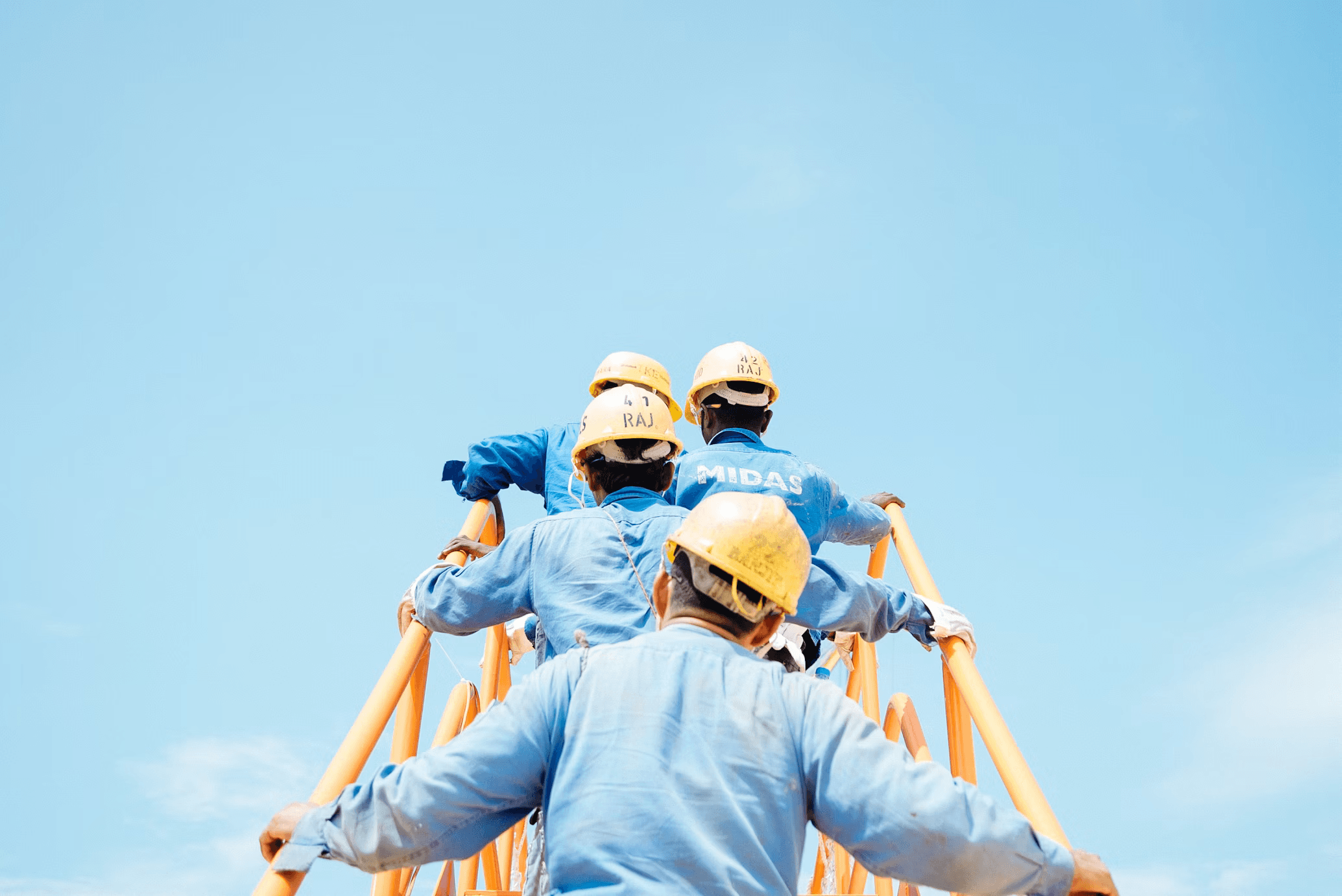 Images of construction workers wearing hard hats and safety vests at a work site