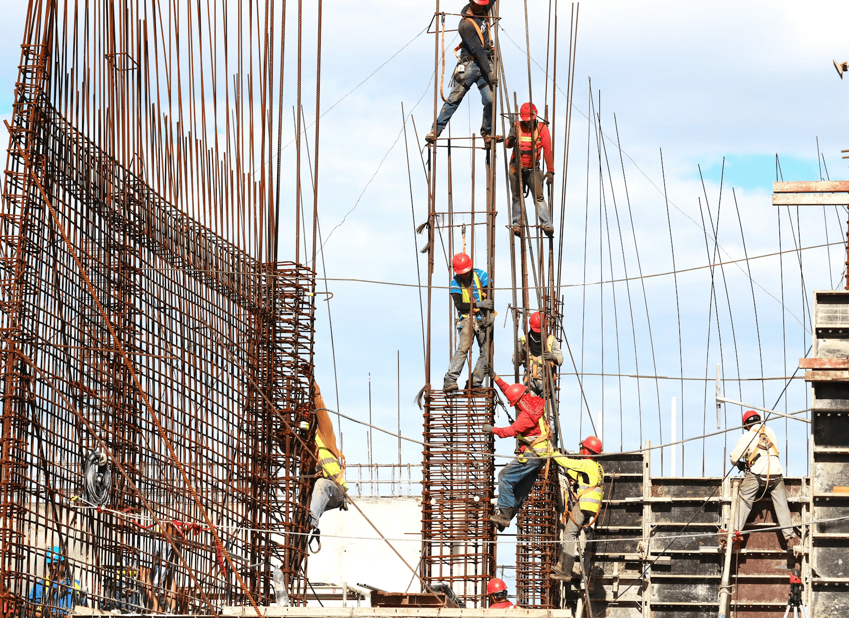 Images of construction workers wearing hard hats and safety vests at a work site