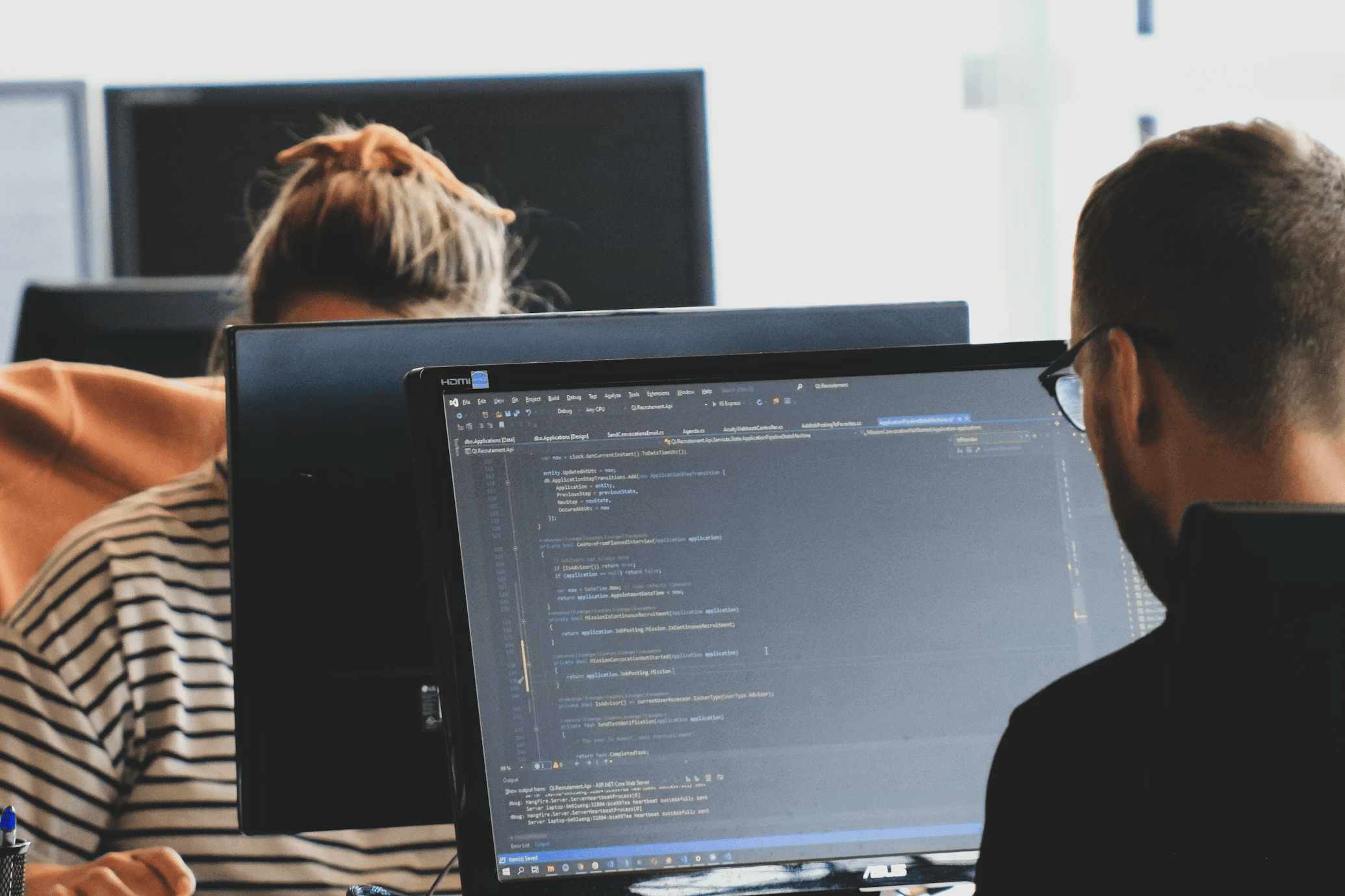 Images of people working on computers in an office setting