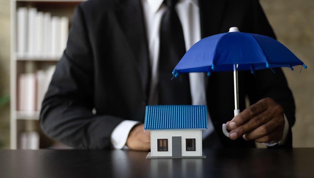Toy house covered by a large umbrella